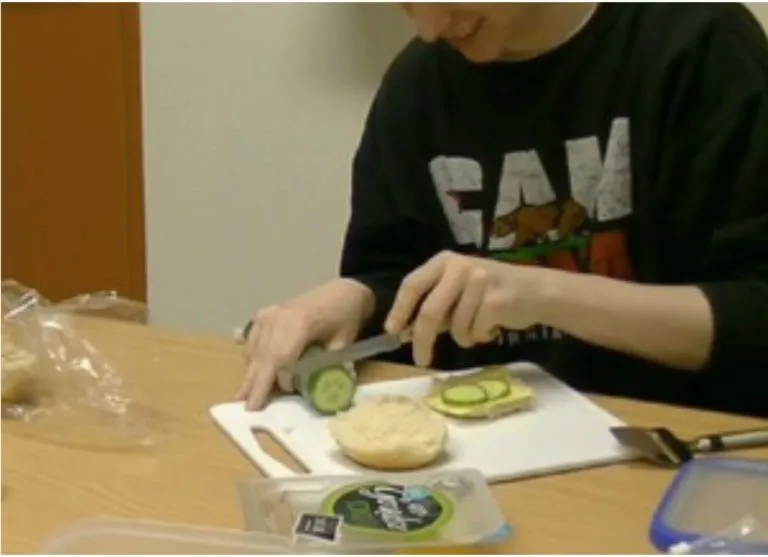 A person making a sandwich with both hands